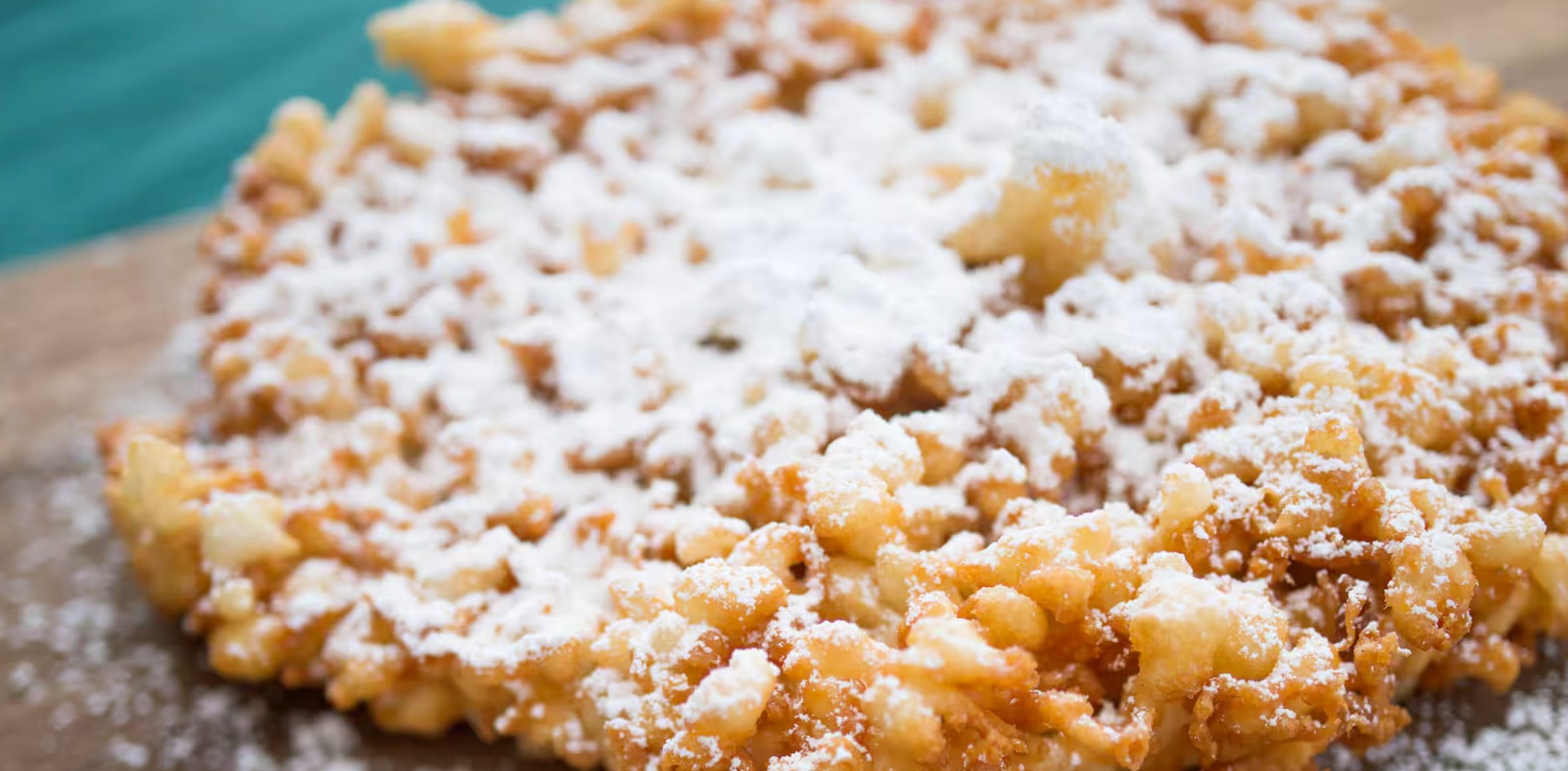 Close-up of rustic apple crumble dessert with buttery streusel topping dusted with powdered sugar.