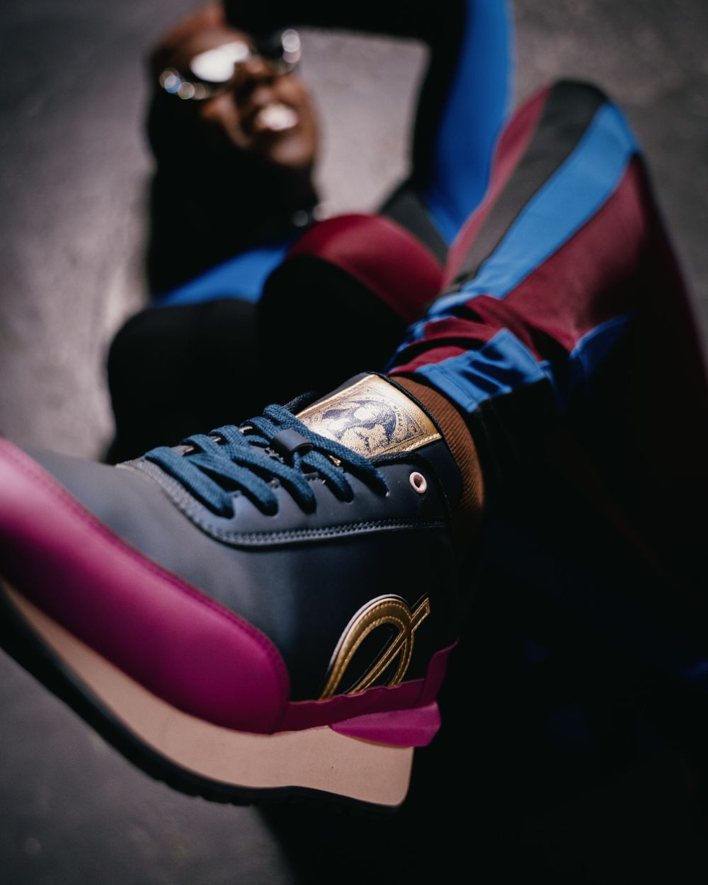 Close-up shot of blue and burgundy sneakers with white soles.