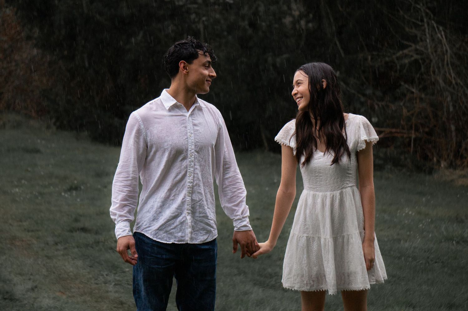 Romantic outdoor couples session with a pair walking together through a grassy field in Pasco WA