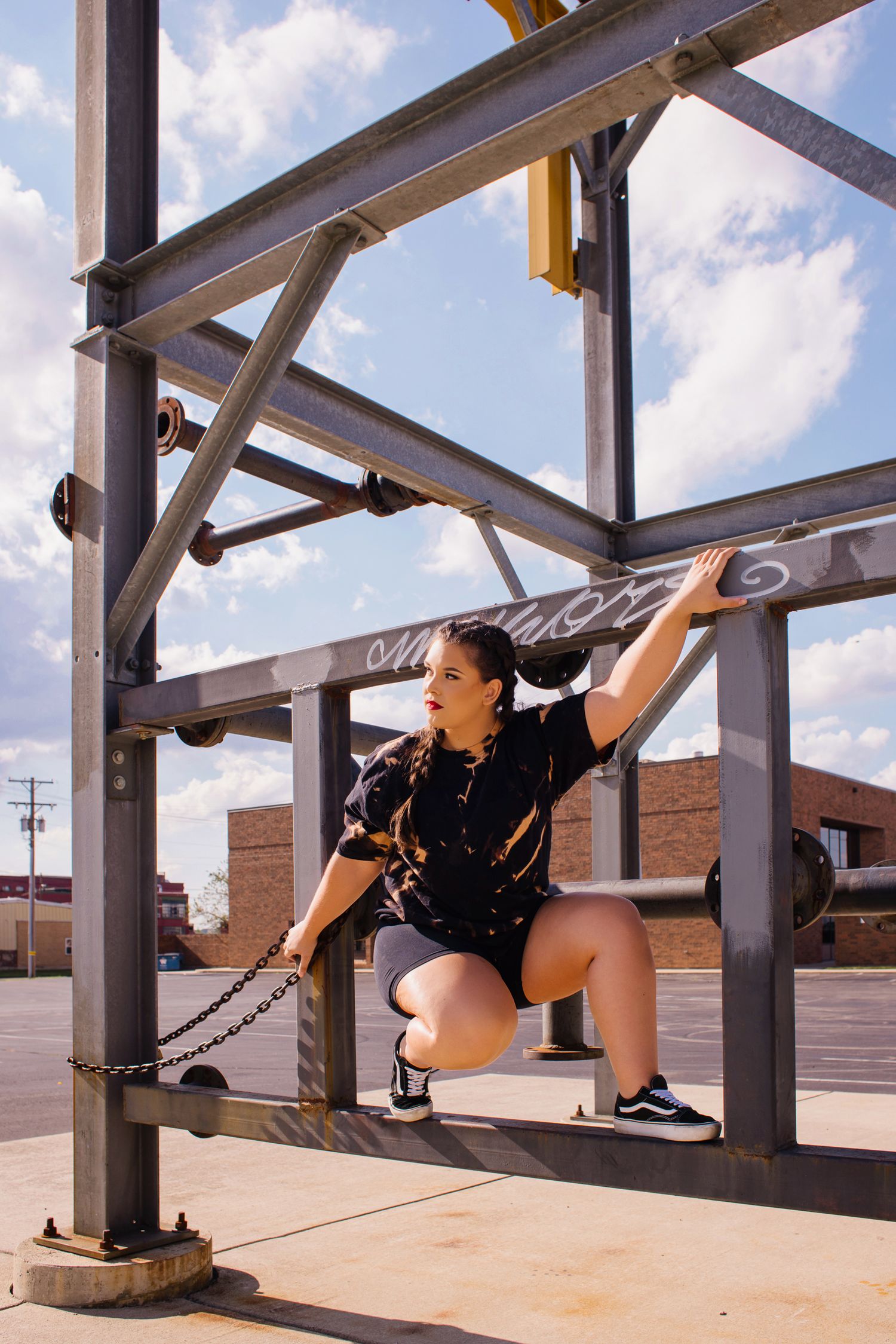 Figure in black athletic wear demonstrates flexibility on metal framework structure.