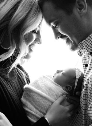 new-parents-looking-down-at-their-newborn-baby-girl