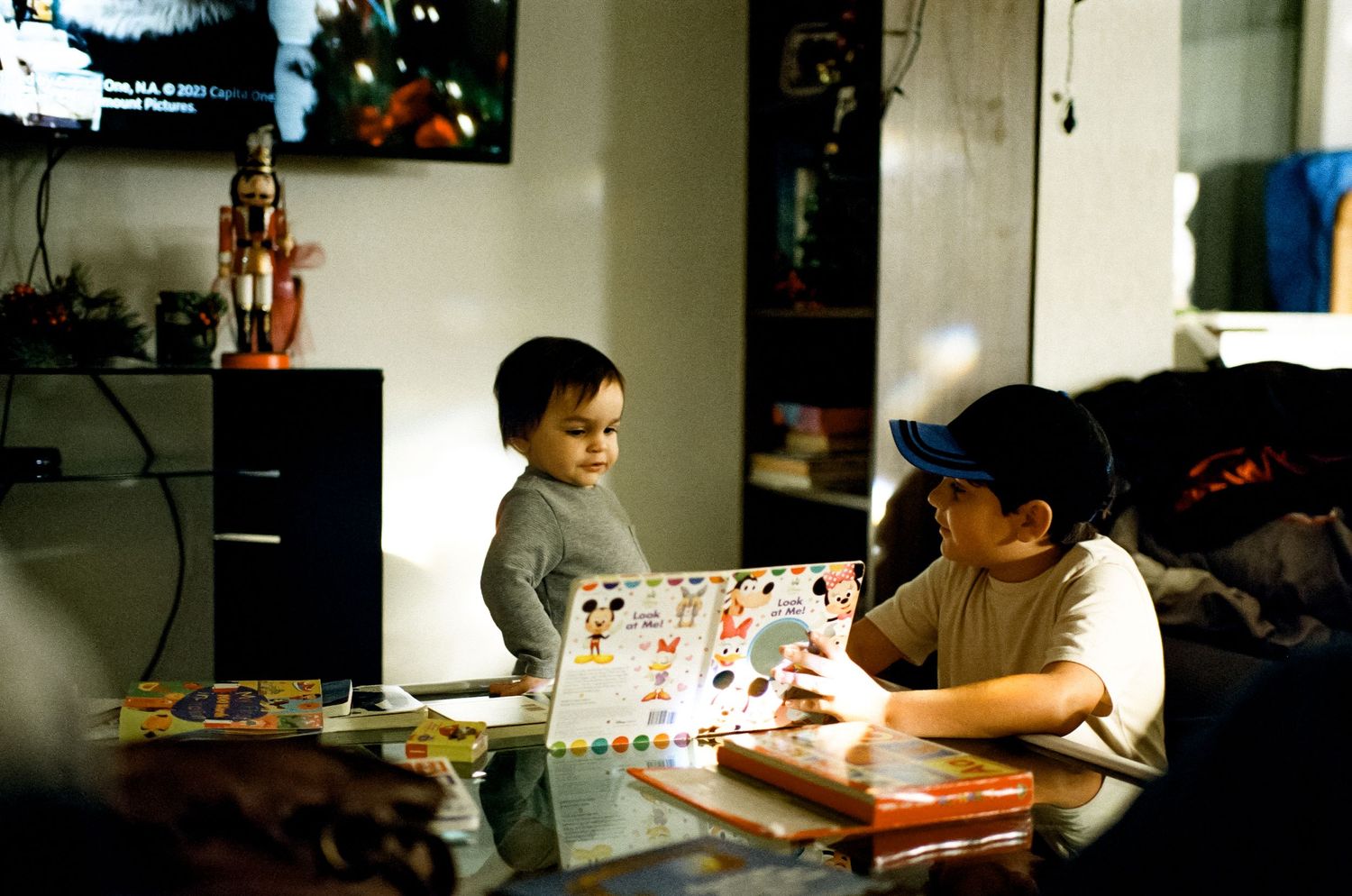 Two people play a board game together at a table in a cozy home setting.