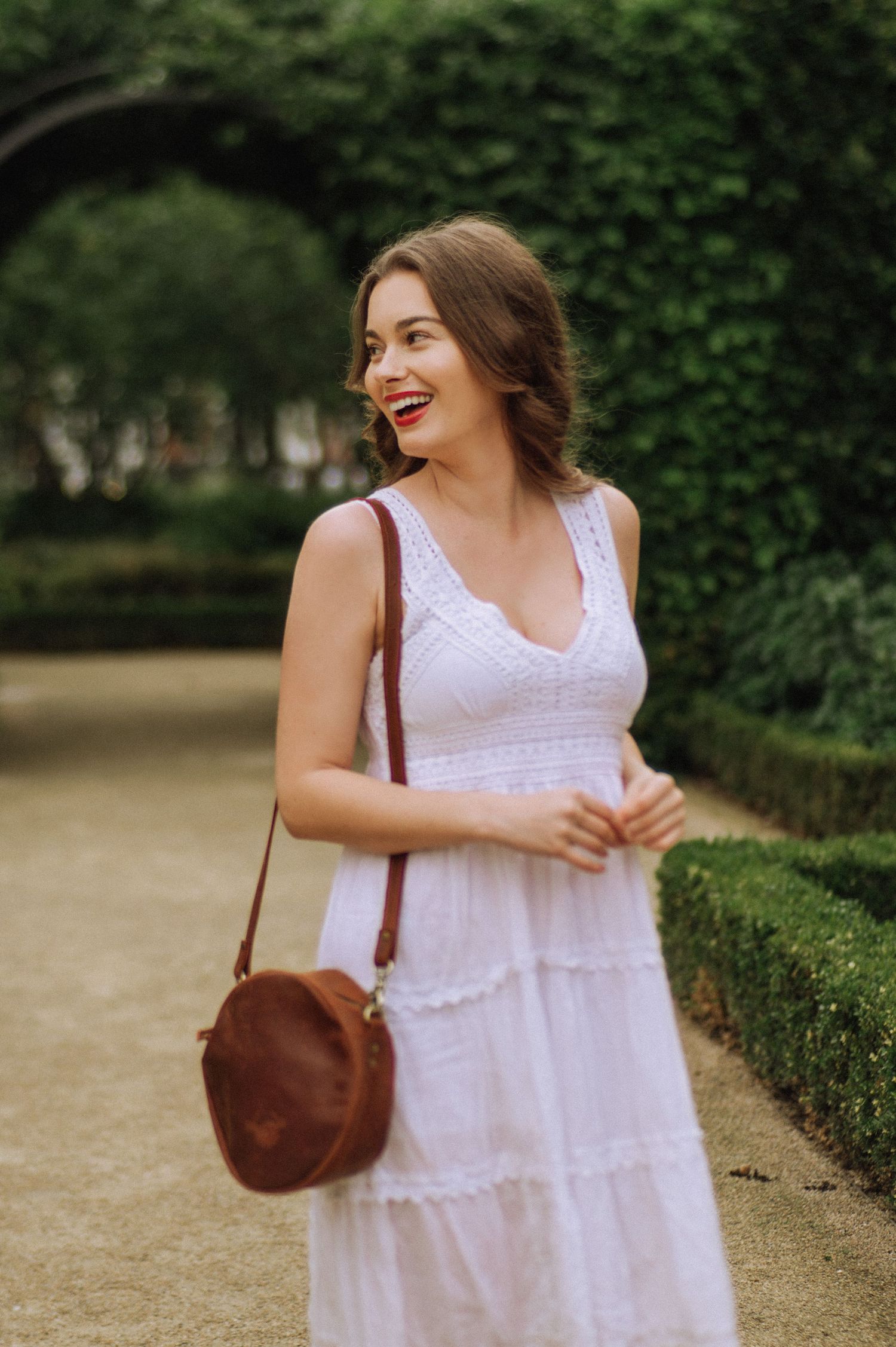 A smiling woman with red lipstick in a park in Amsterdam.