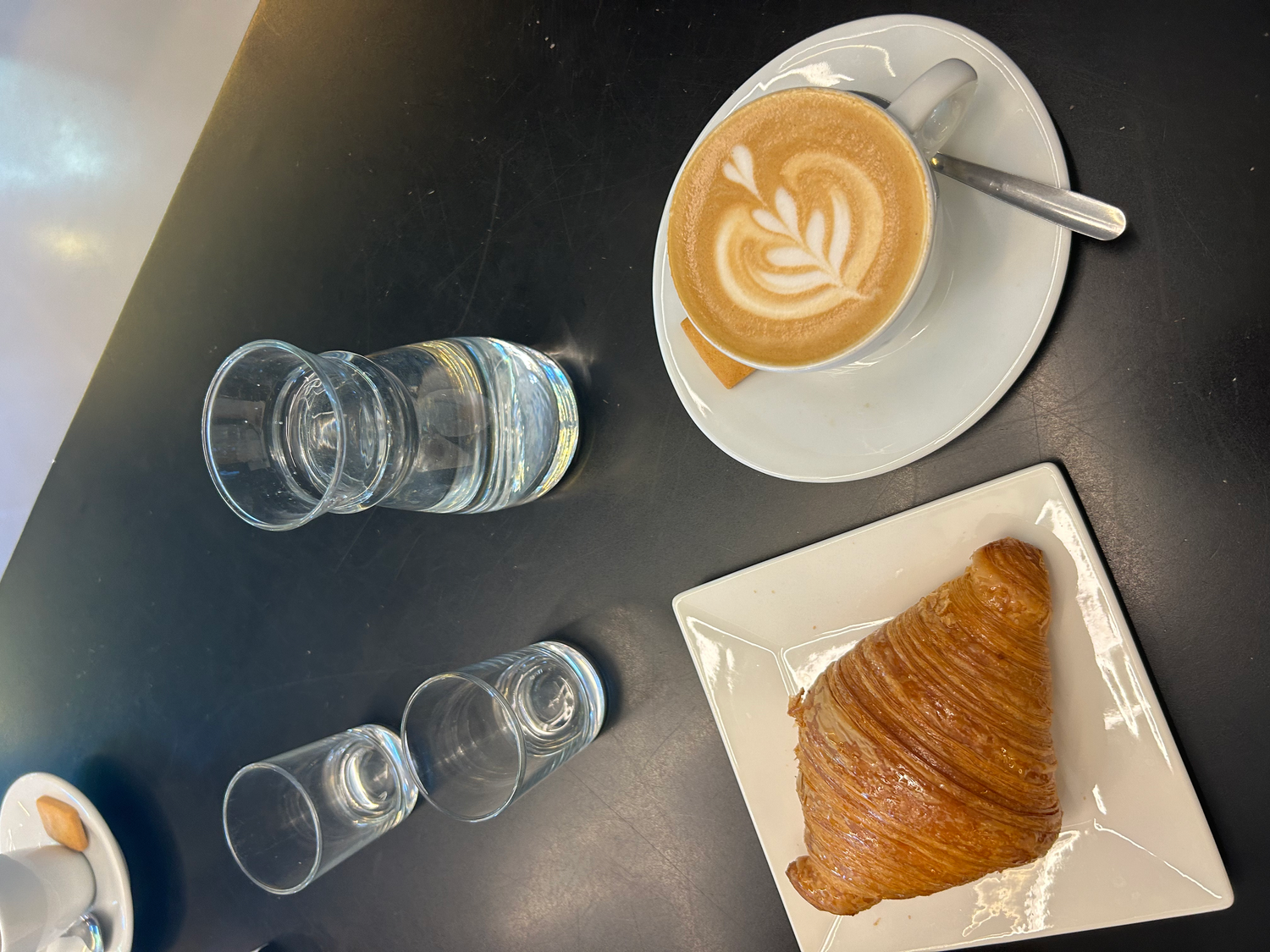A coffee and croissant in a Roman cafe.
