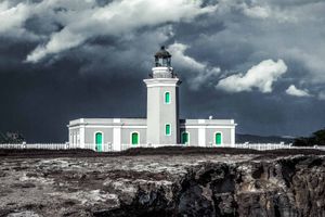 The Arecibo lighthouse in Puerto Rico, overlooking the cliffs with storms in the background.