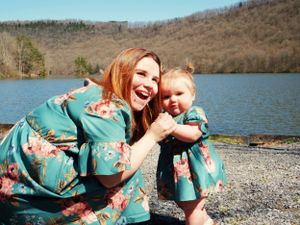 A cheerful moment captured in matching floral outfits against a lakeside backdrop.