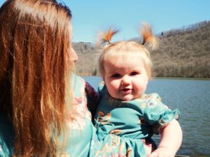 A sunny day at the lake with two people wearing matching floral dresses.