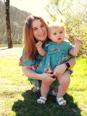 A heartwarming outdoor portrait of two people wearing matching teal floral dresses.