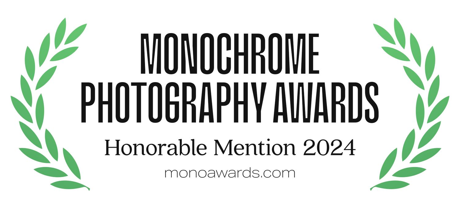 Monochrome Photography Awards Honorable Mention 2024 logo with laurel wreath design.