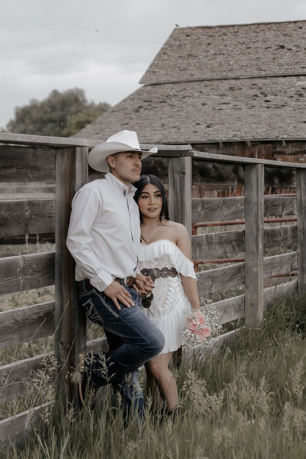 Western couple leaning against a fence