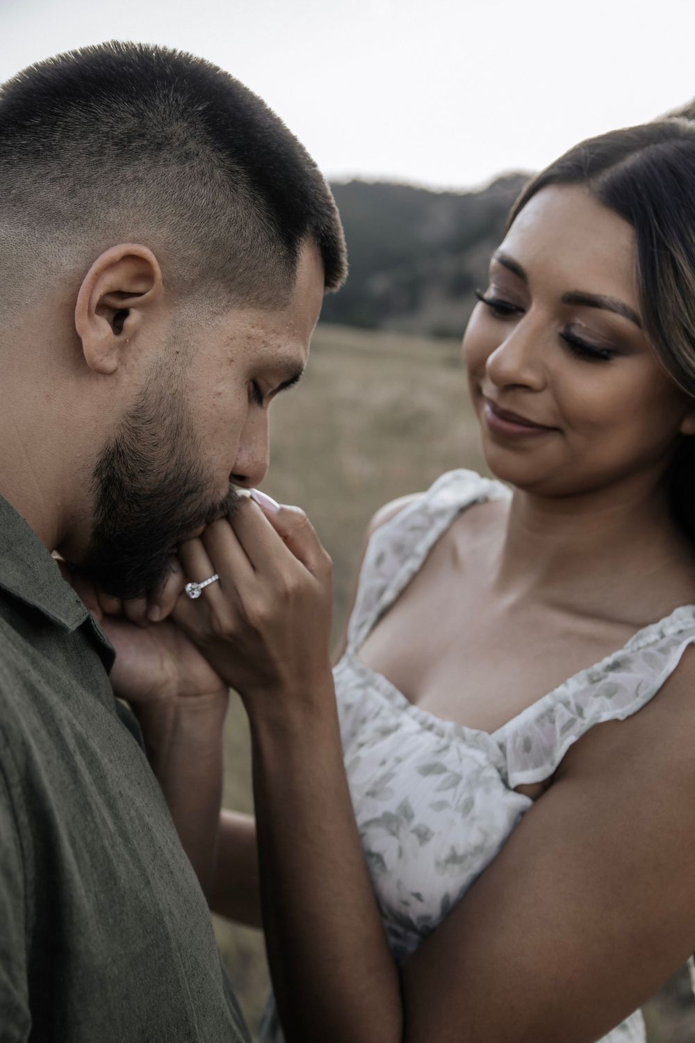 Man kissing his partners hand during golden hour
