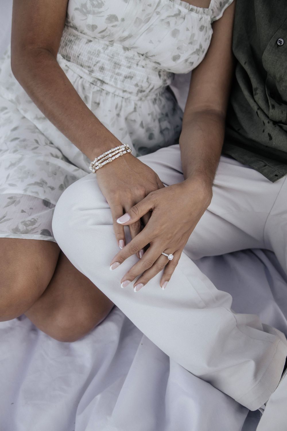 Man and woman snuggling showing off engagement ring