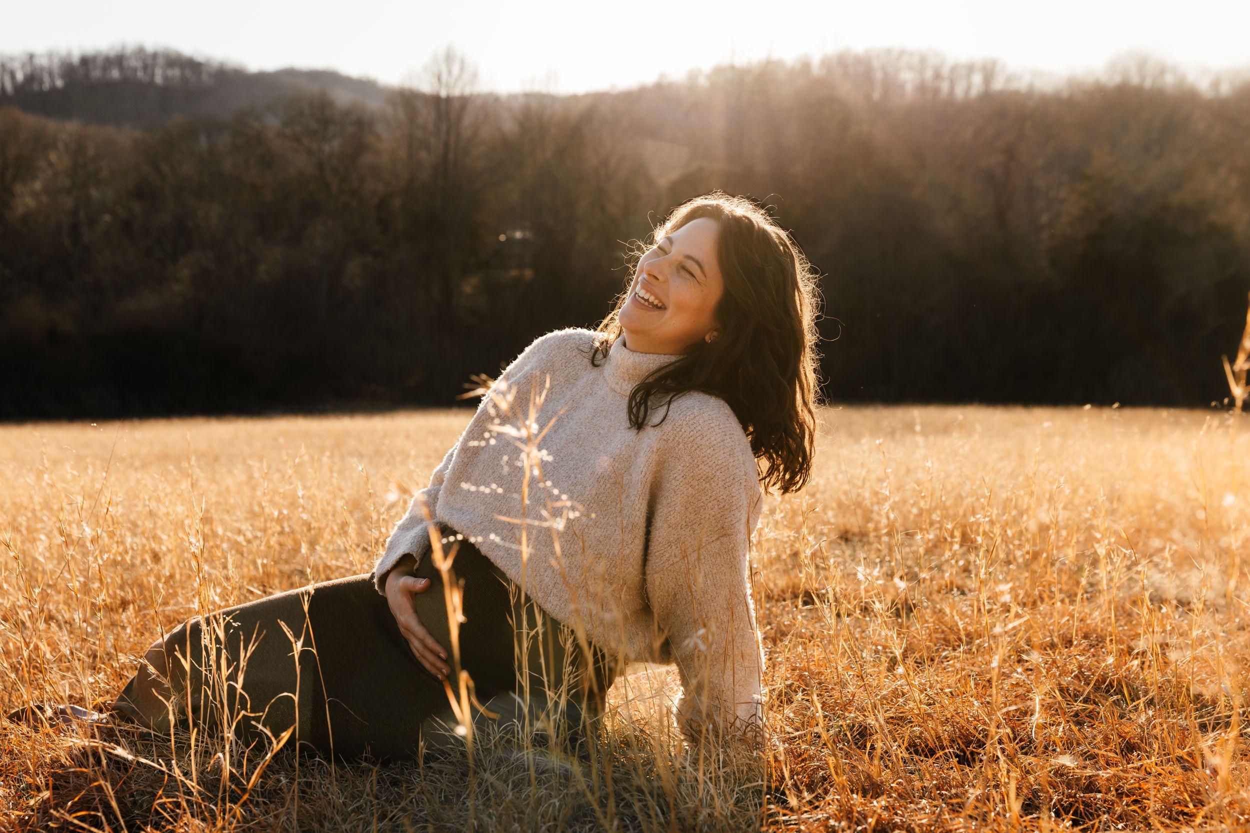 A dreamy golden hour portrait in a wheat field with warm autumn light creating a magical backlit effect.