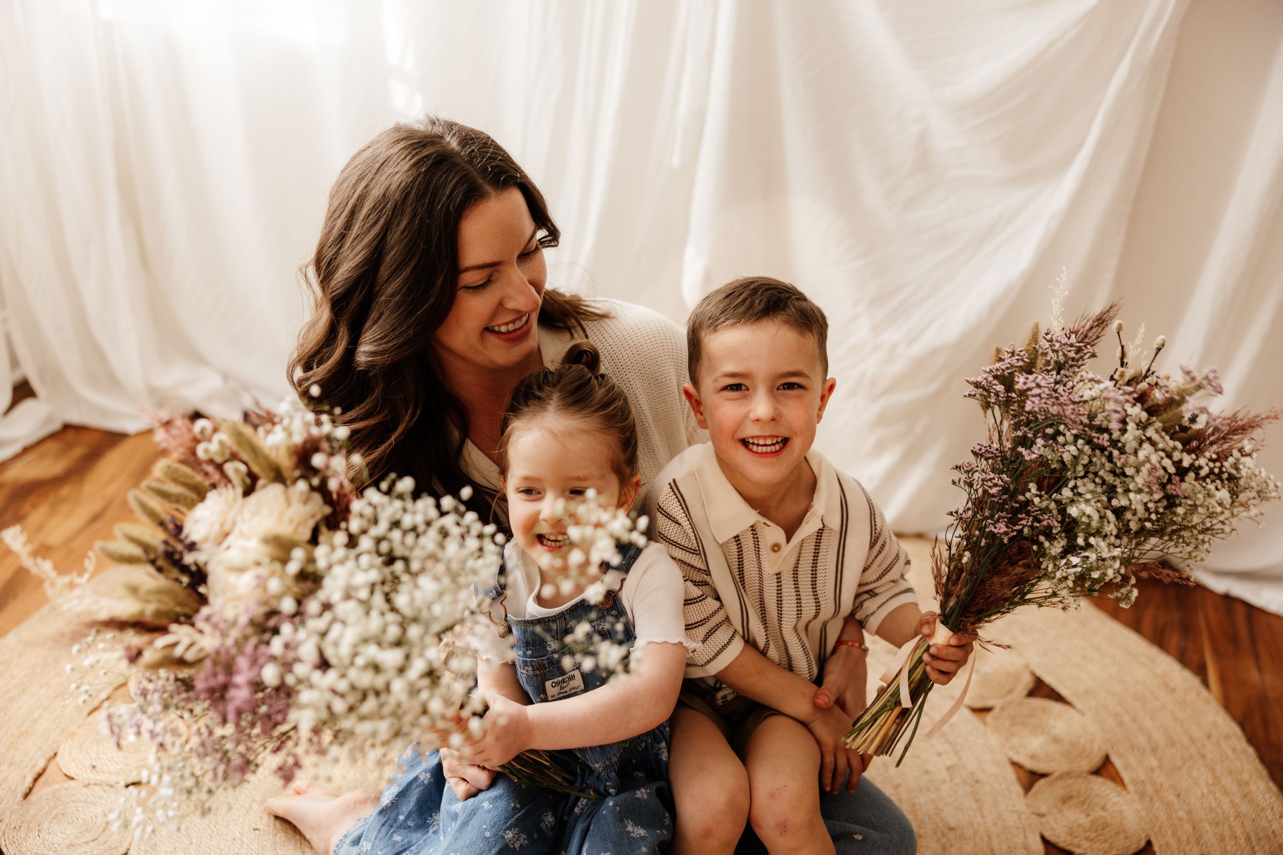 A heartwarming family portrait with dried flowers and baby's breath against a white backdrop.