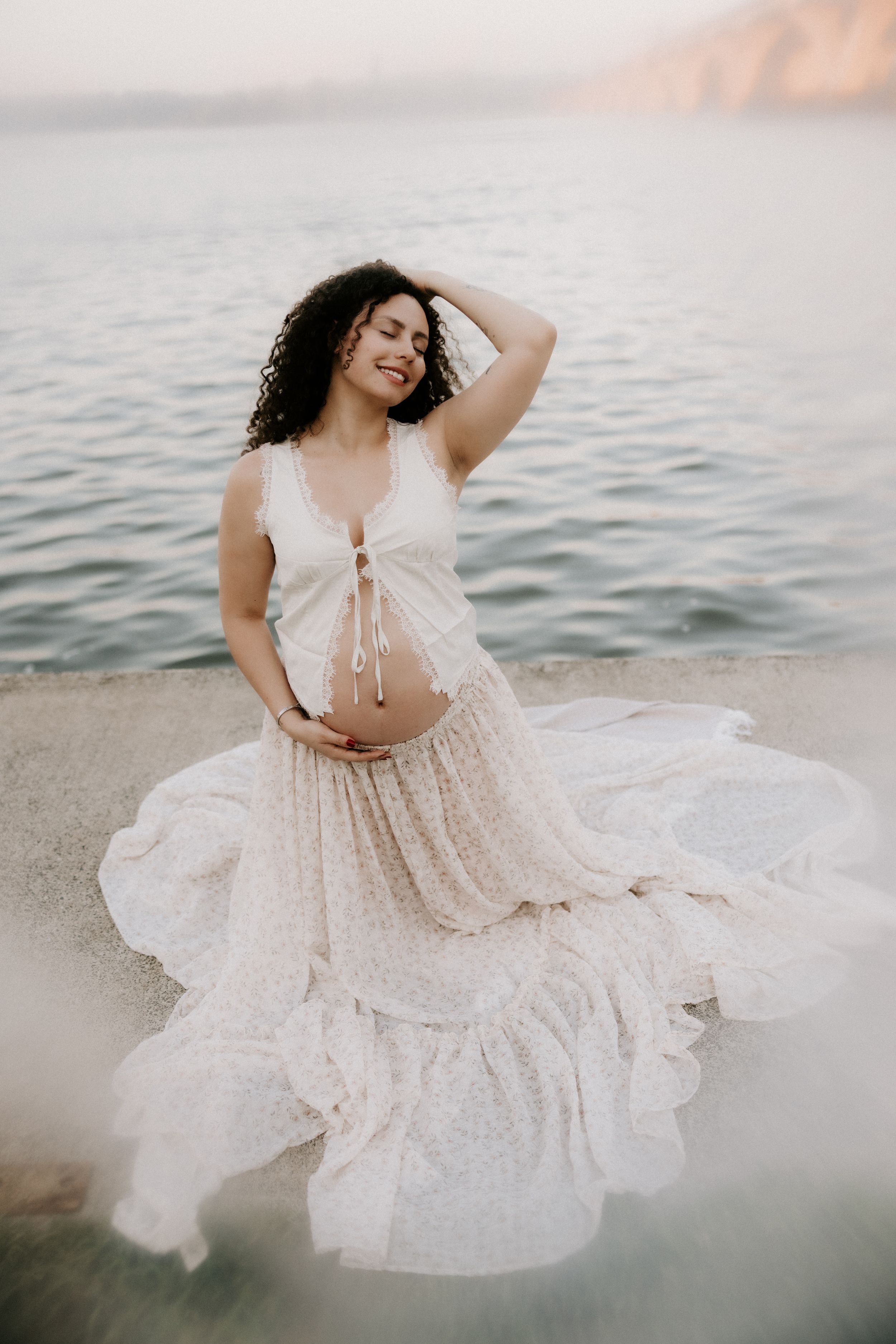 A dreamy beach photoshoot sequence with a flowy white lace dress and gentle waves in the background.