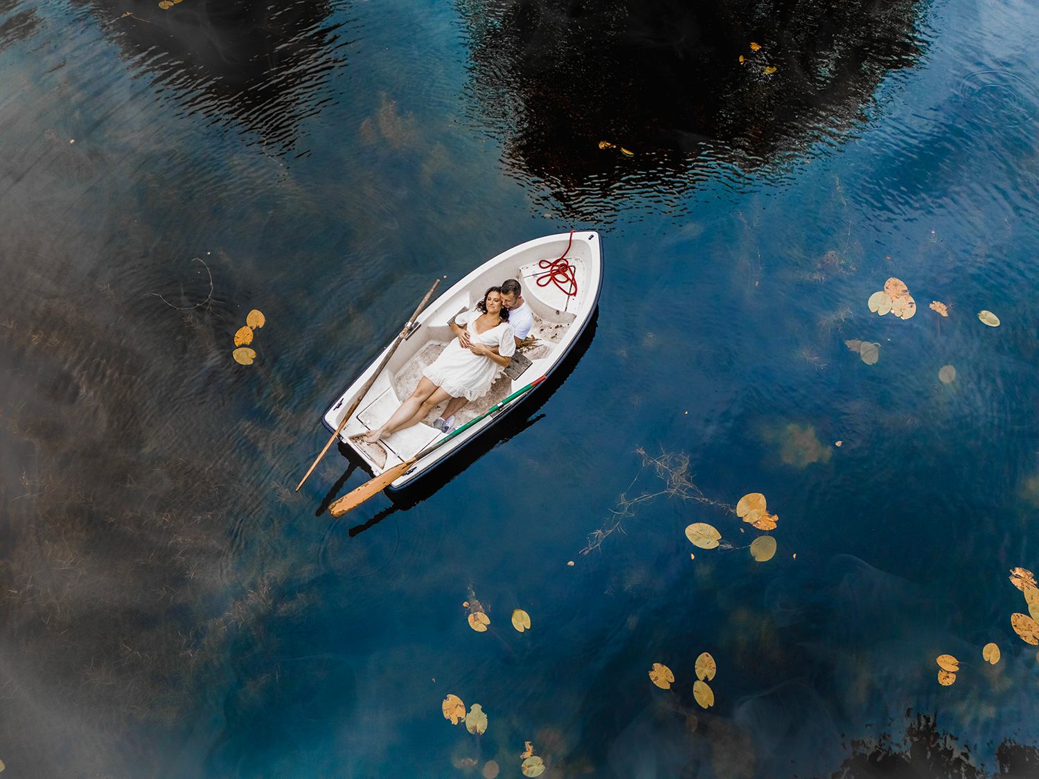 Aerial view of boats scattered across dark blue ocean waters with floating yellow buoys visible.