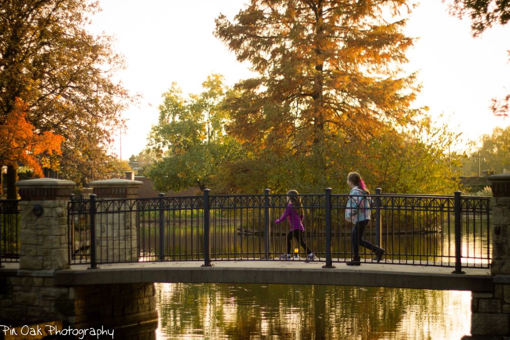 Fall, sunset bridge with children crossing