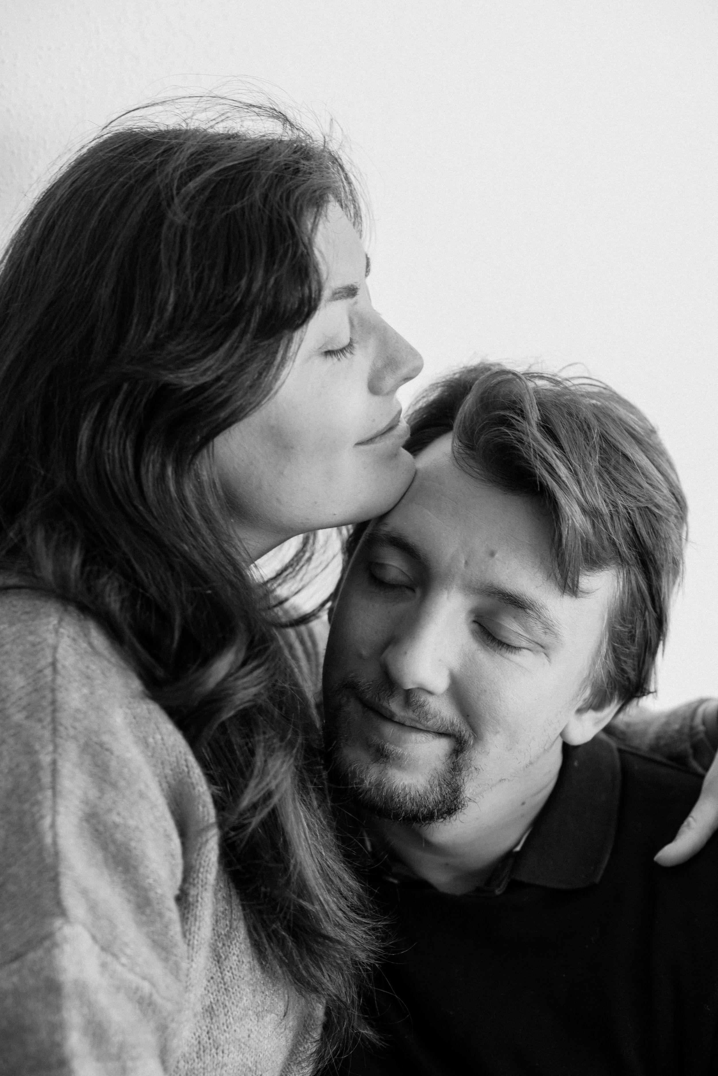 Tender moment captured in black and white as couple shares affectionate embrace.
