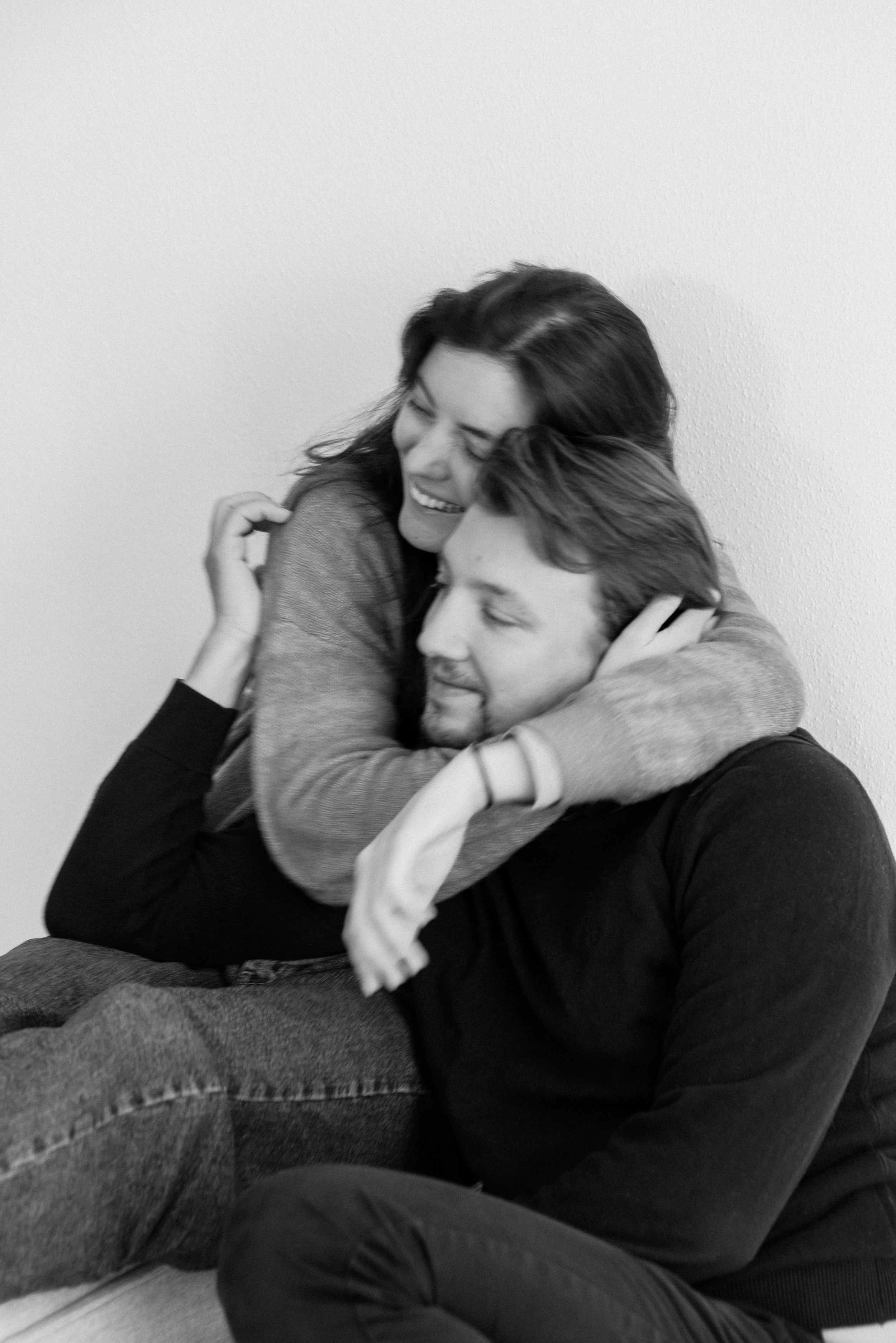Couple sharing playful moments together in black and white portrait series.