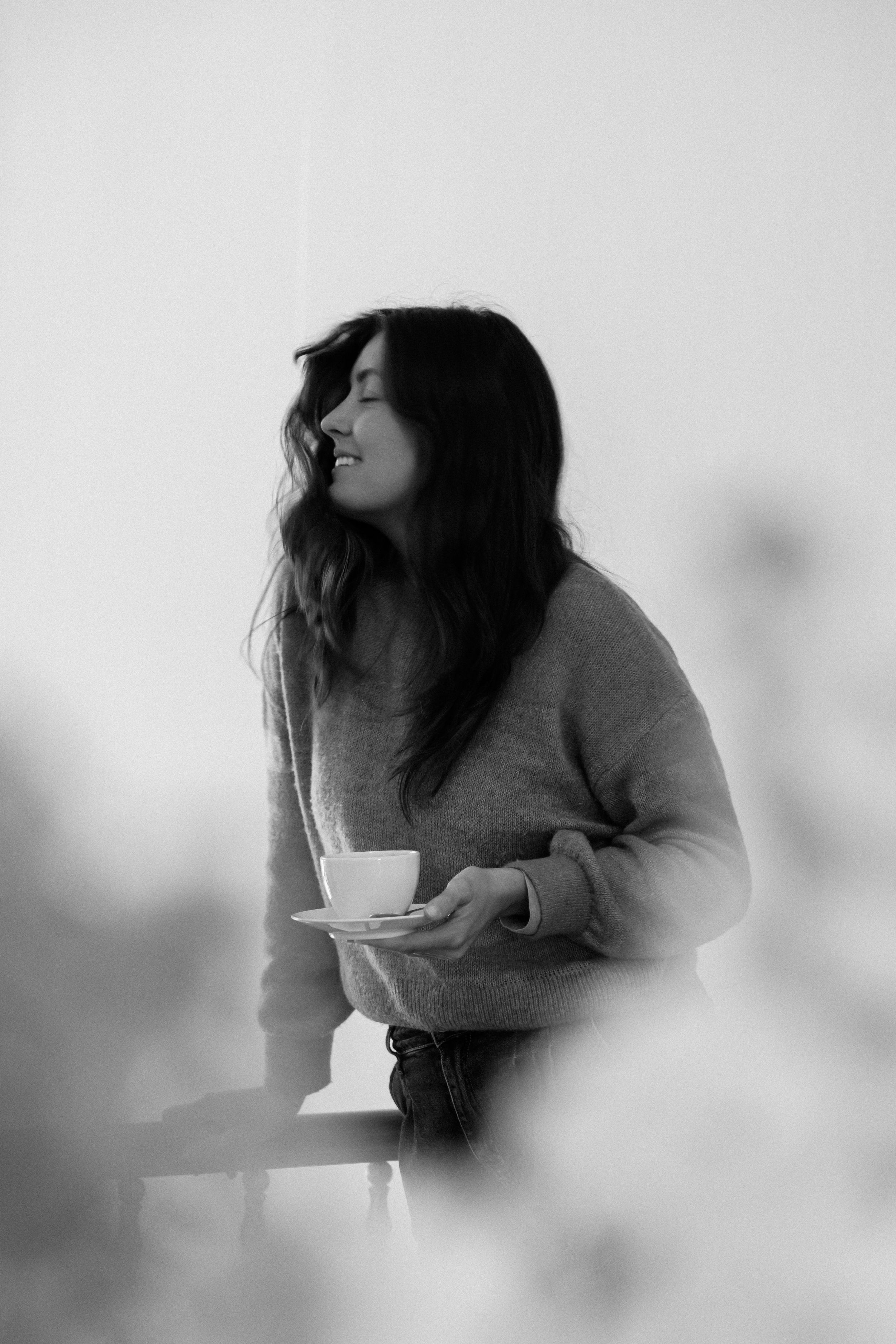 Artistic black and white photograph of someone enjoying a coffee moment.