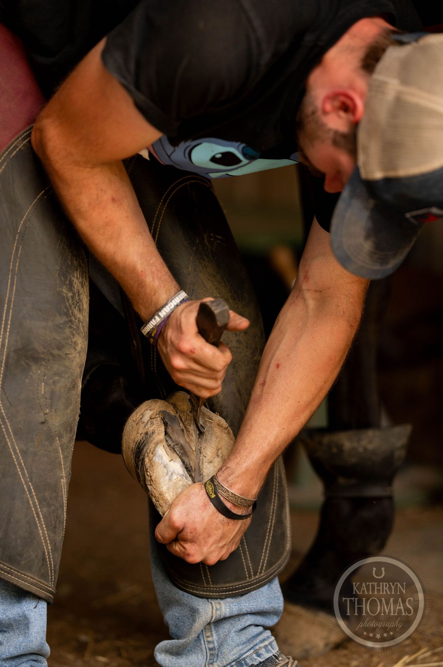 Close-up shot of hands working to shape hoof.