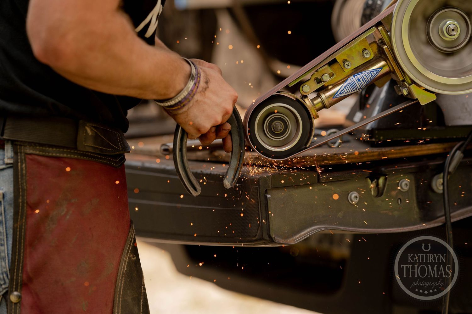 Sparks fly from a grinder being used on metal in a workshop setting.
