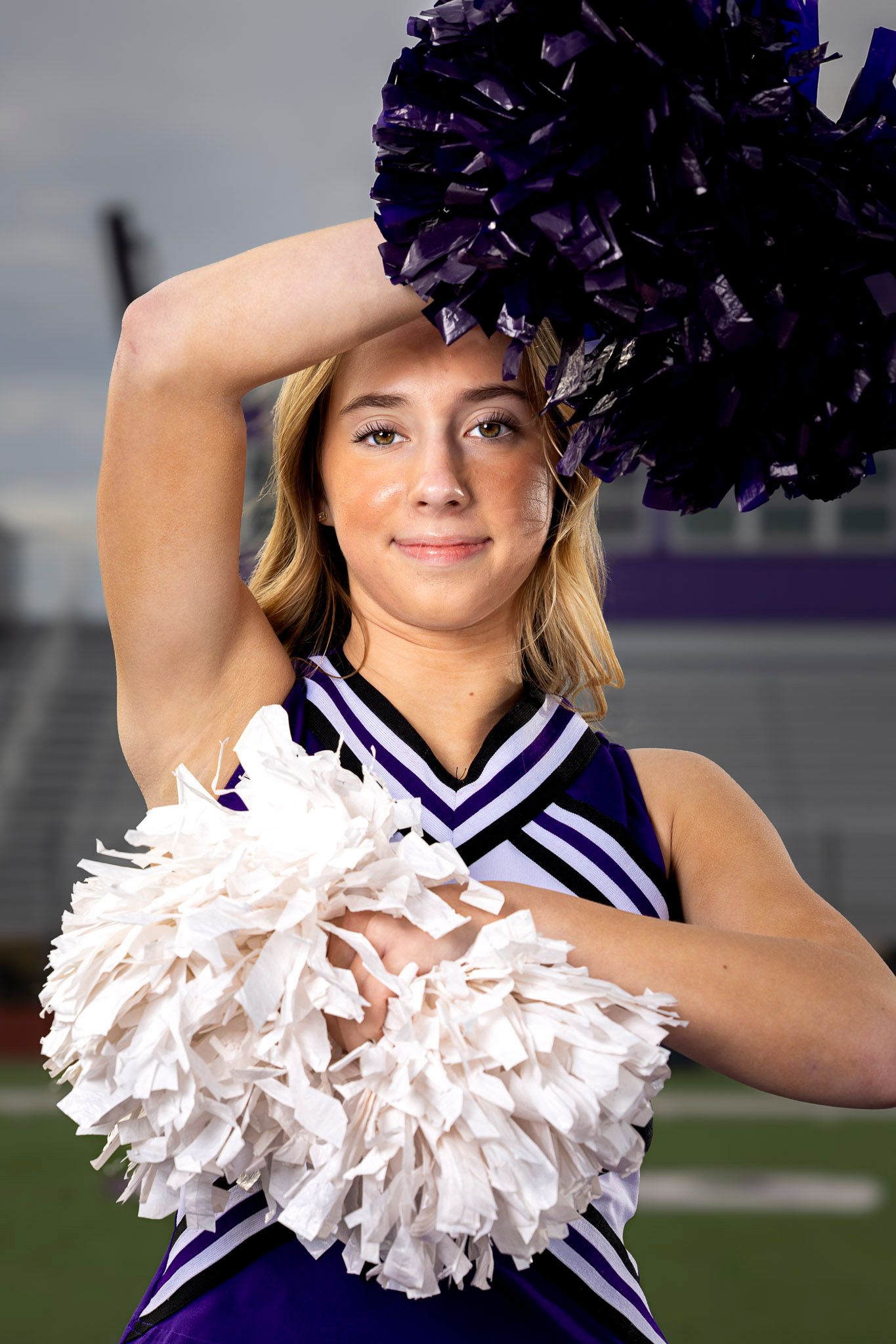 Cheerleader in purple and white uniform poses with pom poms in a sequence of four similar shots.