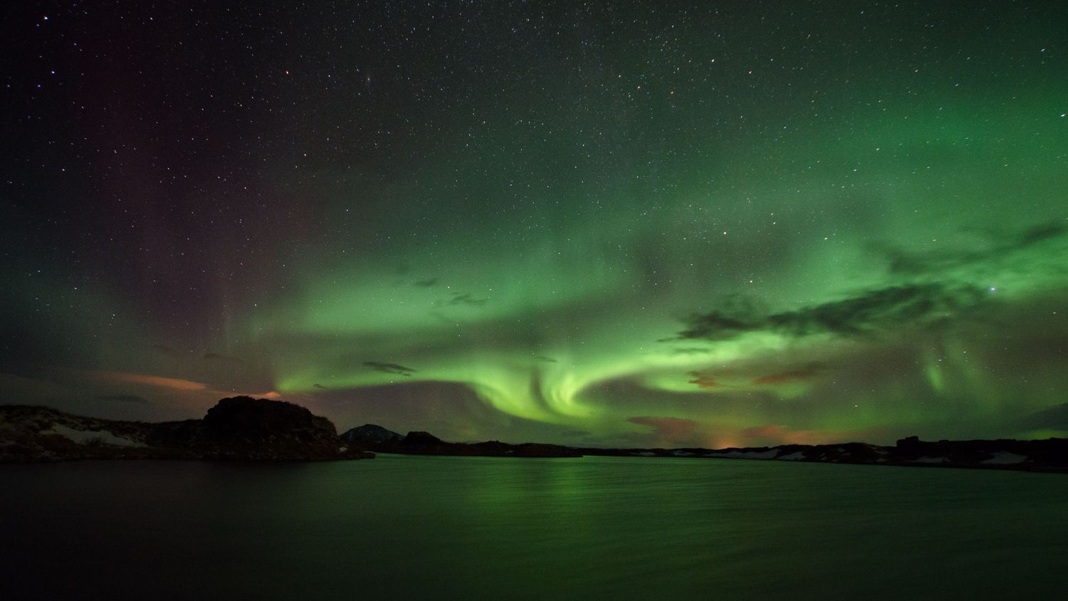 Stunning panorama of the Northern Lights displaying vibrant green aurora across the night sky.