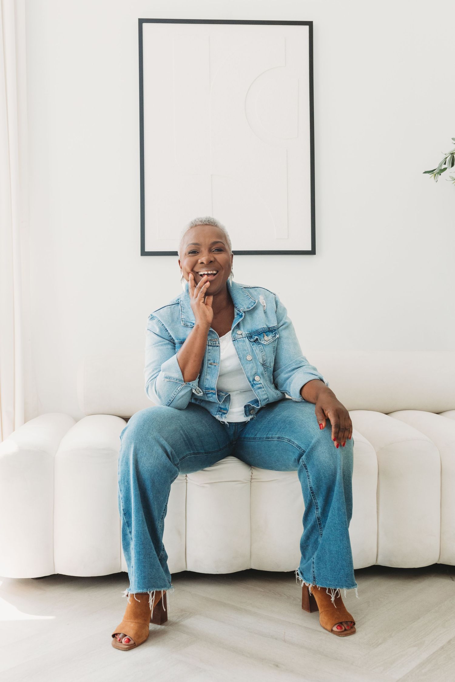 Four photos of someone wearing denim sitting on a white couch in various relaxed poses.