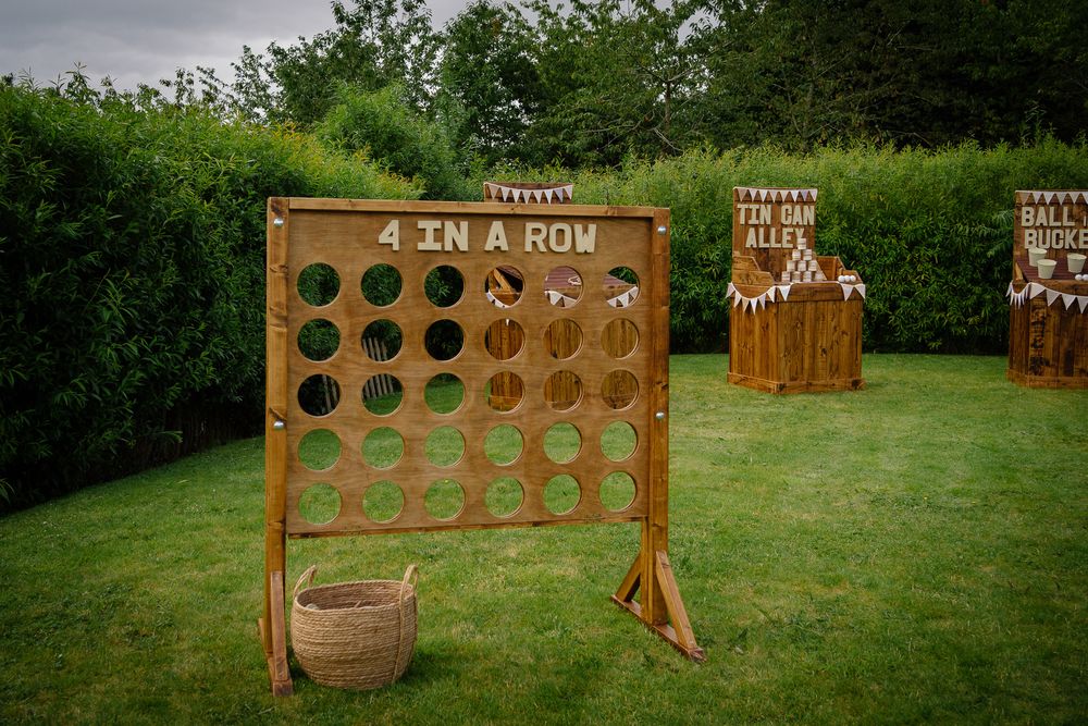 Wooden outdoor connect four game boards set up in a grassy field for outdoor entertainment and fun.