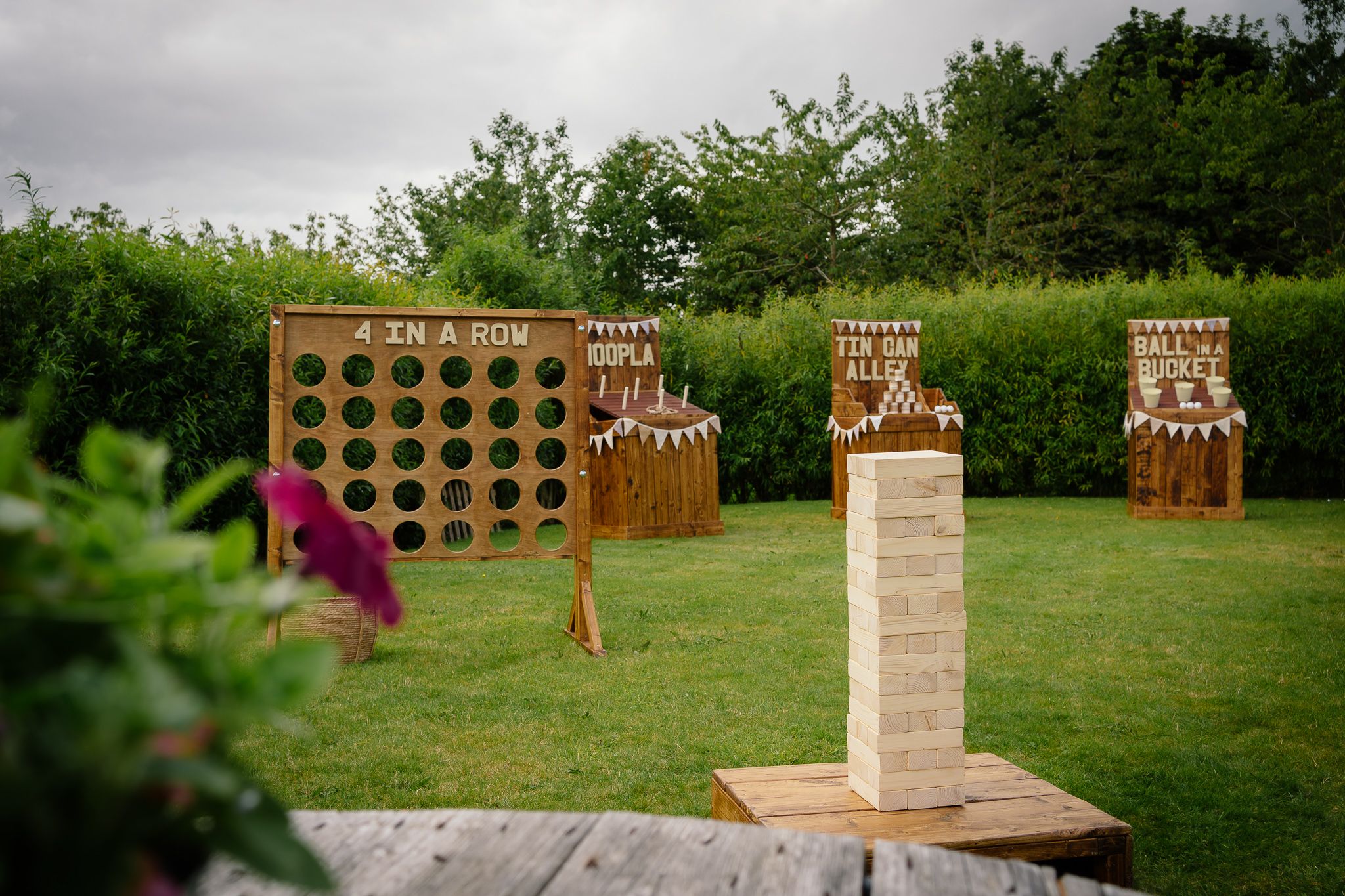 Rustic wooden seating chart display with lattice panels arranged outdoors on a grassy lawn.