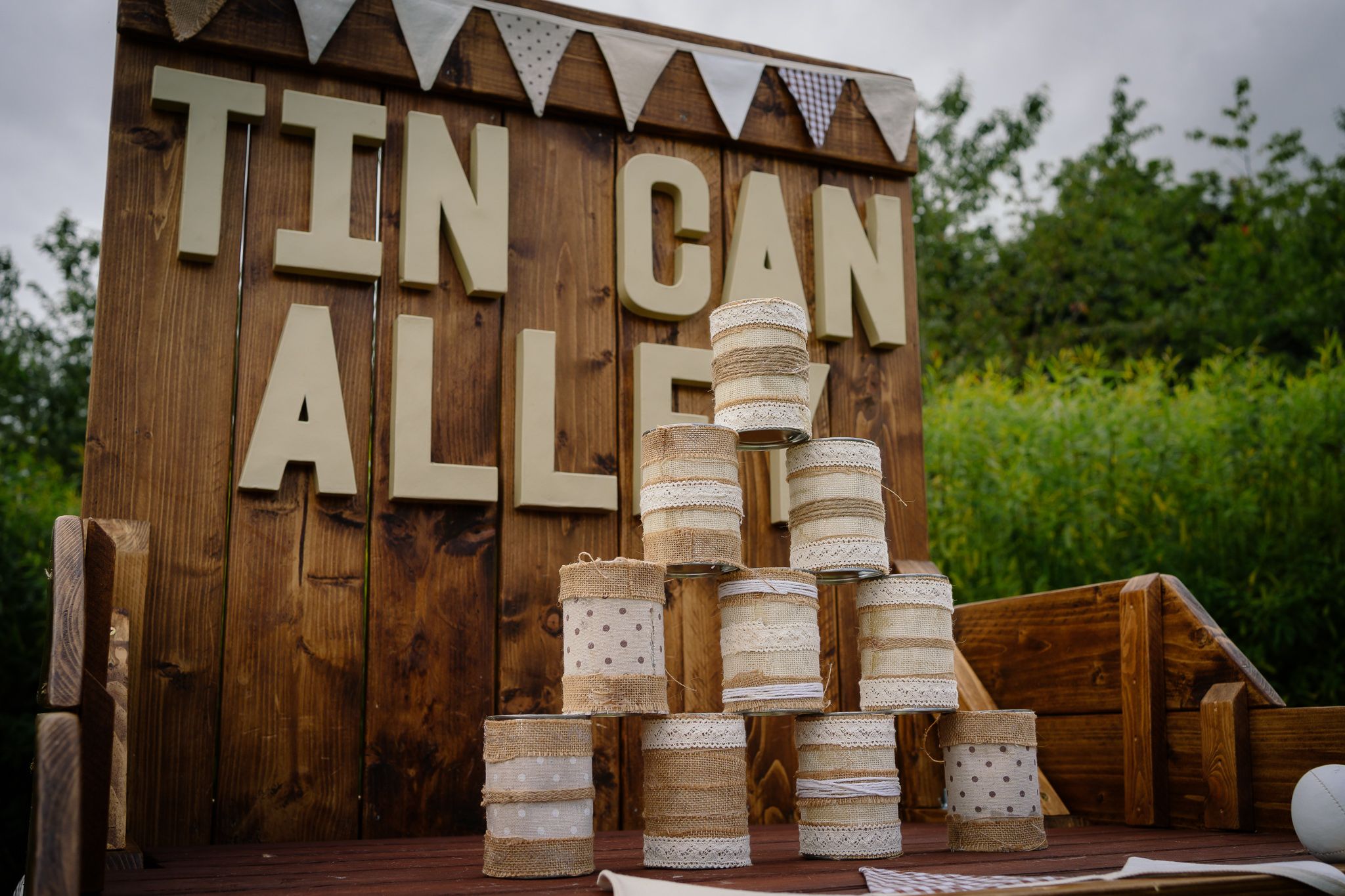 Wooden wedding seating chart with white paper signs arranged alphabetically on brown panels.