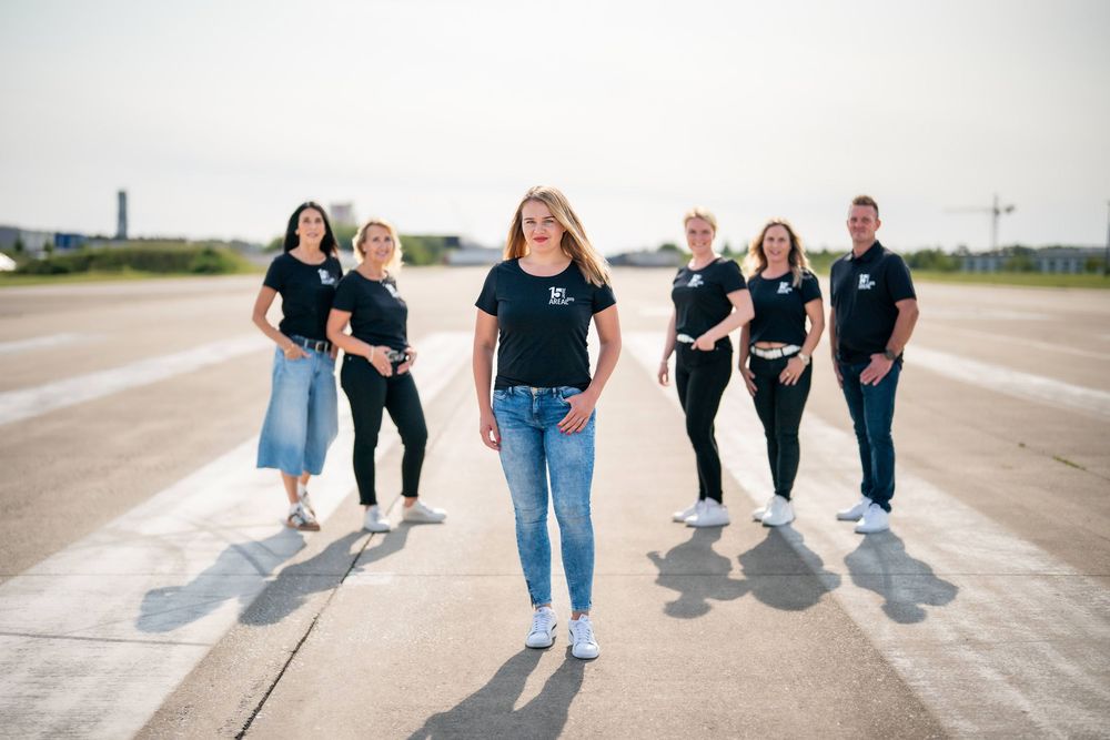 Group of friends walking together casting long shadows on an empty road on a sunny day.
