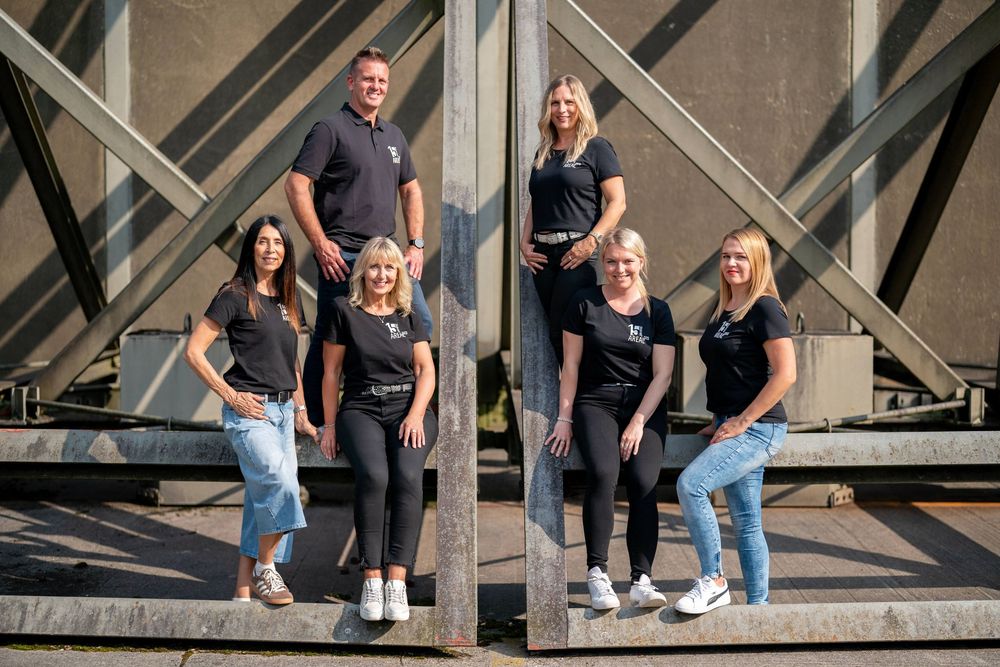 Group poses casually on urban concrete steps wearing athletic wear and jeans.