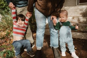 Low angle shot of family members playing and interacting on front steps.