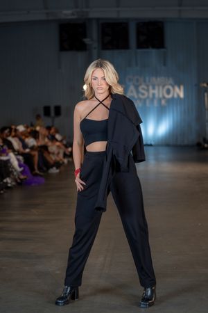 Model presents black asymmetrical outfit with cutout detail at Columbia Fashion Week.