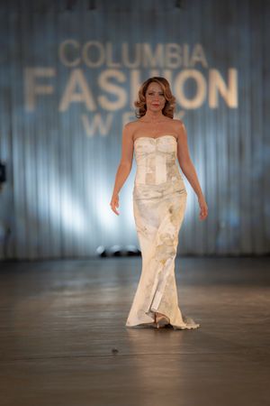 Elegant strapless cream gown on display at Columbia Fashion Week runway show.