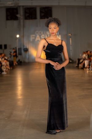 A sleek black velvet floor-length gown with spaghetti straps displayed at Columbia Fashion Week.