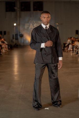 Classic black suit with wide-leg trousers showcased on runway at Columbia Fashion show.