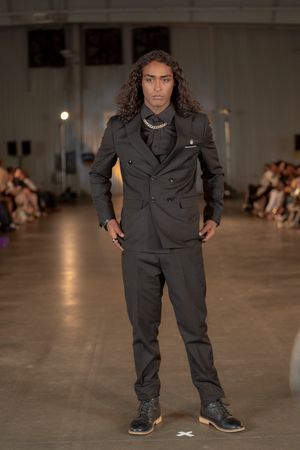 A charcoal gray double-breasted suit styled with sneakers on the Columbia Fashion Week catwalk.