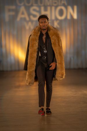 Luxurious brown fur coat styled over black ensemble shown at Columbia Fashion Week.