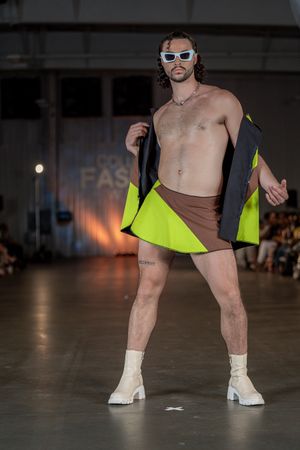 Model wears neon accented outfit with white boots at Columbia Fashion Week.