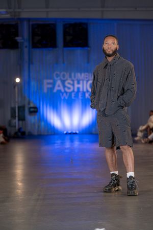 Model presents casual grey streetwear look with boots at Columbia Fashion Week.