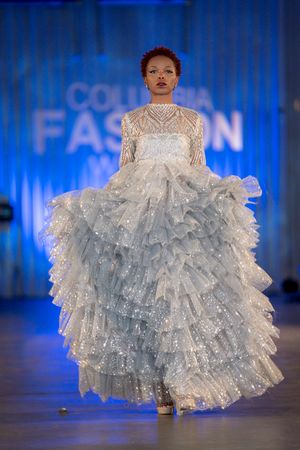 Ethereal white ruffled ball gown with high neck and layered tulle skirt at Columbia Fashion Week.
