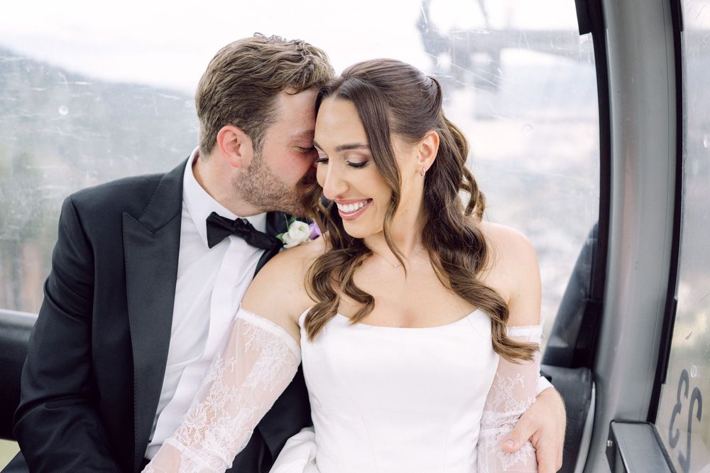 A romantic moment between newlyweds inside what appears to be a gondola or ski lift cabin.