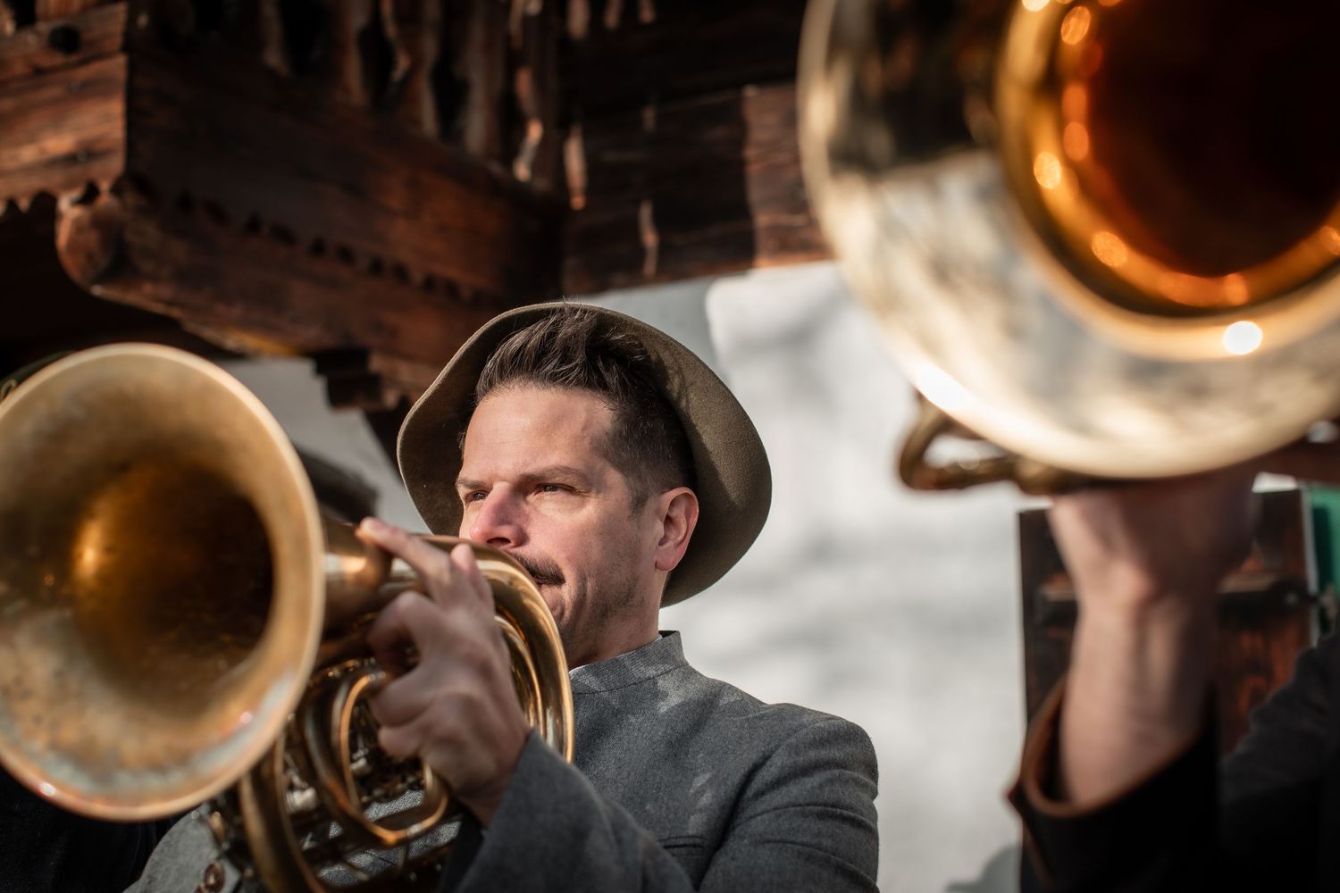 Musikant aus Bayern spielt in Tracht ein Flügelhorn oder Trompete. Er trägt einen Trachtenhut. Klaus Lerner von der Duanixmusi. Da Schachten