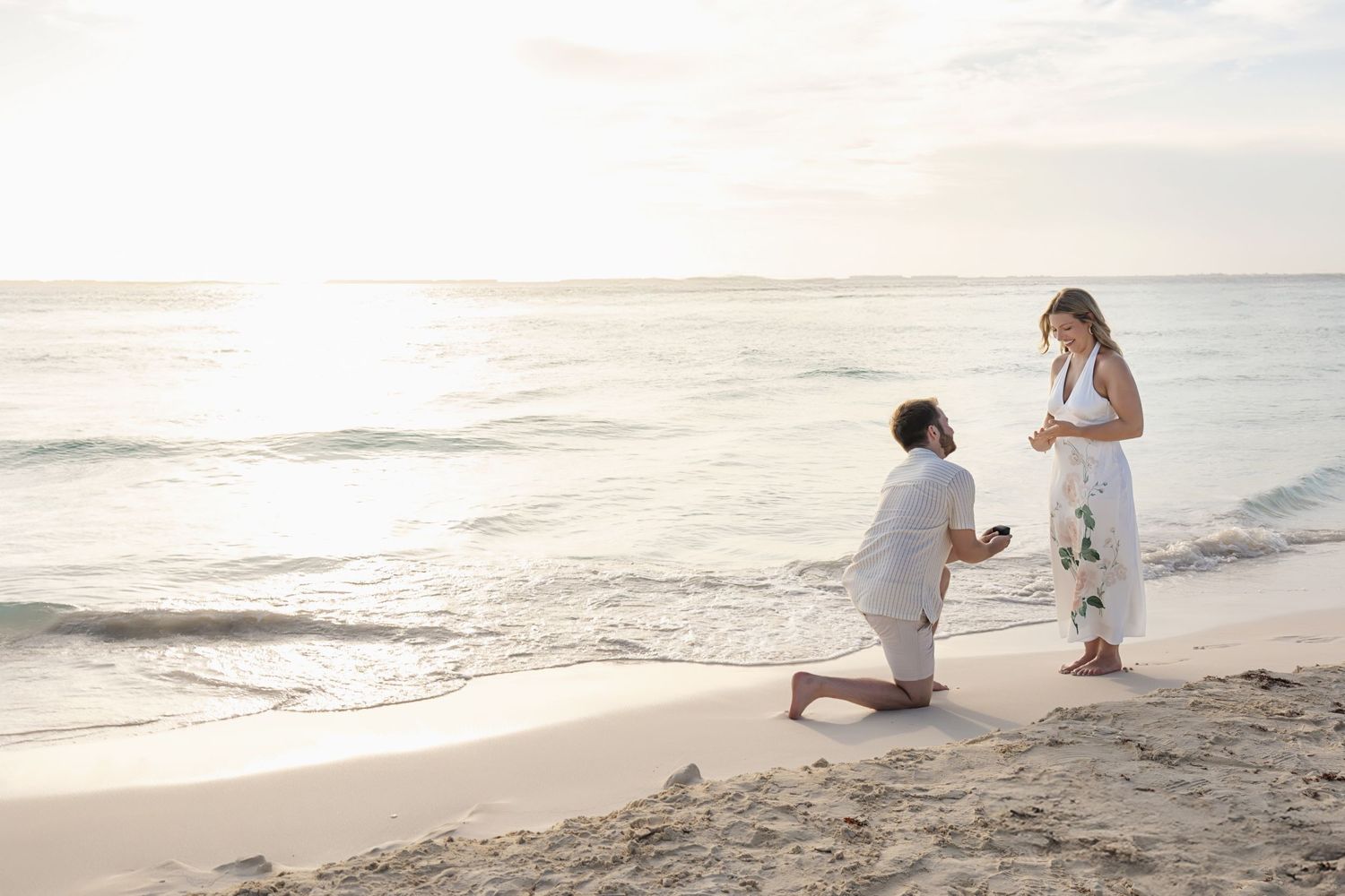 Surprise proposal at Playa Norte with Connor on one knee as Natalie reacts with joy