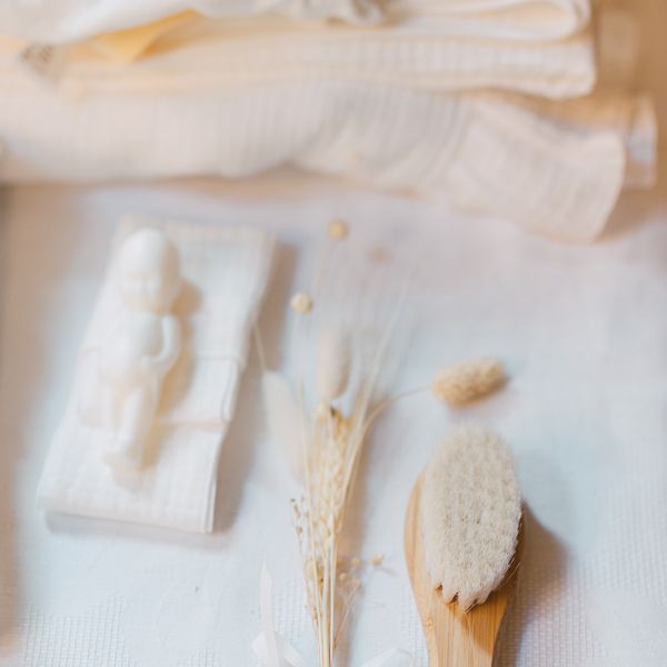 Collection of vintage white bath accessories and brushes arranged on a light surface.