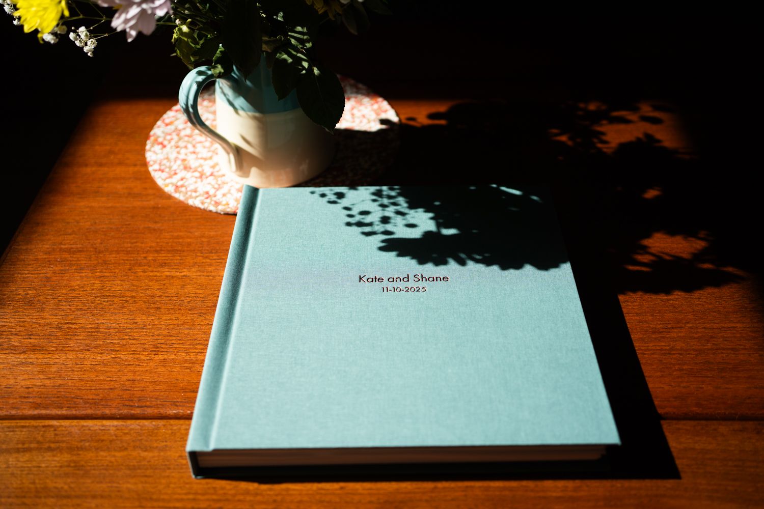 A series of five images showing a book being opened progressively on a wooden surface with dramatic lighting.