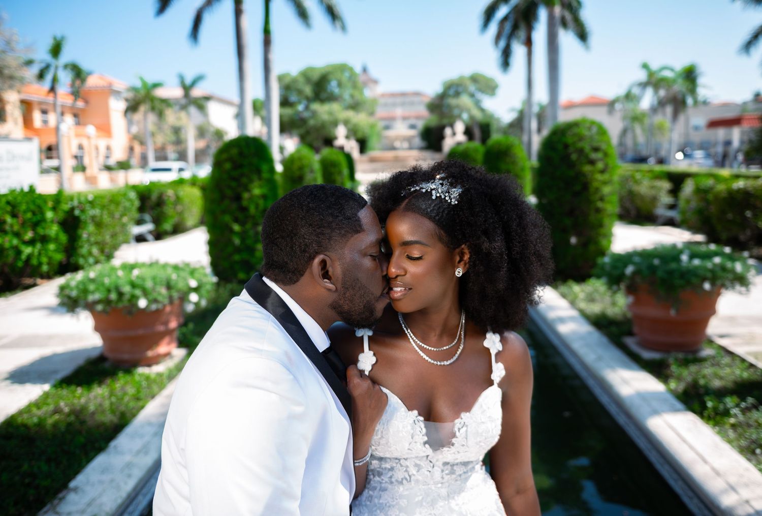 The groom kisses his bride near Worth Avenue in Palm Beach, captured by South Florida wedding photographers.